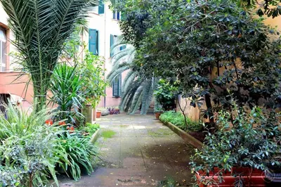 a garden with trees and plants and a building at Karol Apartment Rome in Rome