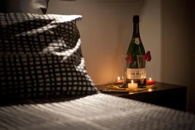 a bottle of wine sitting on a table with candles at Chroma Italy - Chroma Apt Campo de' Fiori in Rome
