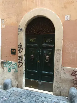a black door with graffiti on the side of a building at Chroma Italy - Chroma Apt Campo de' Fiori in Rome