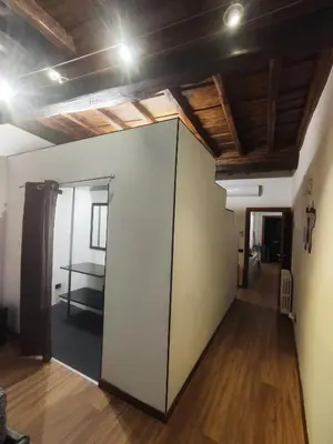 a room with a large door in a room with wooden ceilings at Chroma Italy - Chroma Apt Campo de' Fiori in Rome