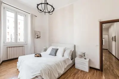 a white bedroom with a large bed and a mirror at The Best Rent - Three-bedroom apartment in Porta Maggiore area in Rome