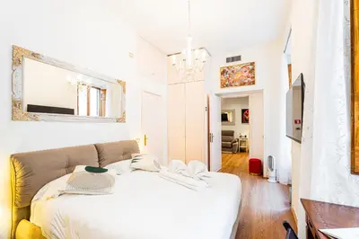 a white bedroom with a bed and a mirror at The Eclectic Loft Spagna in Rome