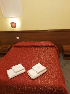 two towels on a red bed in a room at B&B Rudy Center in Rome