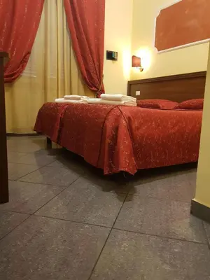 a bedroom with two beds with red sheets at B&B Rudy Center in Rome