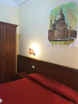 a bedroom with a bed with a painting on the wall at B&B Rudy Center in Rome