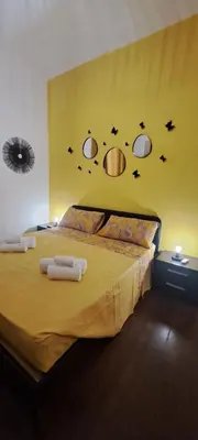a bedroom with a bed with a yellow wall at Central Rome Suite in Rome