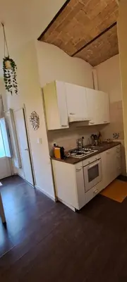a kitchen with white cabinets and a stove top oven at Central Rome Suite in Rome