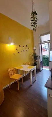 a room with a table and chairs and a yellow wall at Central Rome Suite in Rome