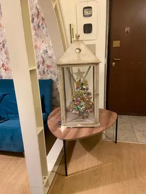 a table with a lantern with a christmas tree in it at Blue vatican house Rome in Rome