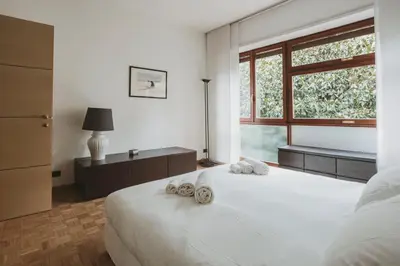 a bedroom with a large white bed with towels on it at EasyTopStay - Peaceful Retreat near San Pietro in Rome