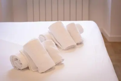 a group of white towels sitting on a bed at Colosseo Modern by Rental in Rome in Rome