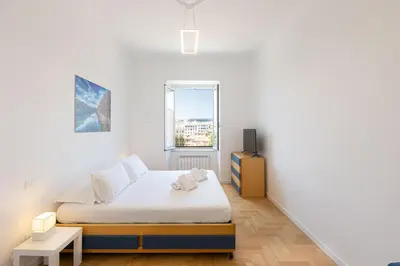 a white bedroom with a bed and a window at Colosseo Modern by Rental in Rome in Rome