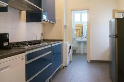 a kitchen with blue cabinets and a sink and a refrigerator at EasyTopStay - Piazza Navona Charming Apartment in Rome