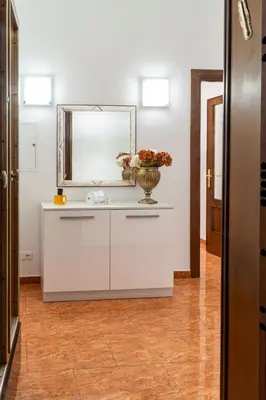 a bathroom with a mirror and a vase with flowers on a counter at La Maison D'Amelia in Rome