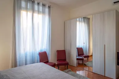 a bedroom with two red chairs and a mirror at La Maison D'Amelia in Rome