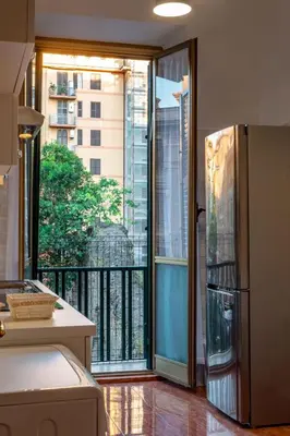 a kitchen with a refrigerator and a large window at La Maison D'Amelia in Rome