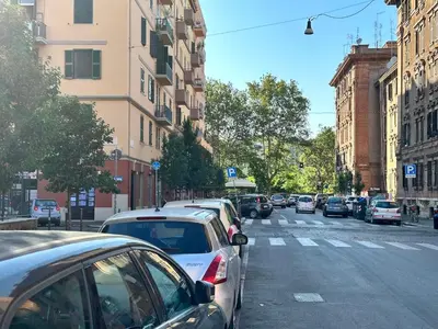 a city street with cars parked on the side of the road at La Maison D'Amelia in Rome