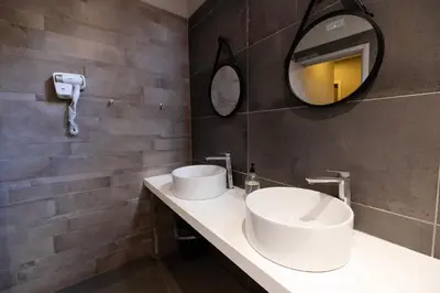 a bathroom with two sinks and a mirror at Borgo Ripa Urban Travel in Rome