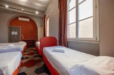a room with three beds and a window at Borgo Ripa Urban Travel in Rome