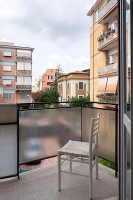 a chair on a balcony with a view of a building at Nel cuore di Monteverde in Rome