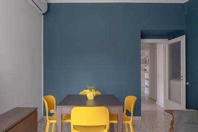 a dining room with a table and yellow chairs at Nel cuore di Monteverde in Rome