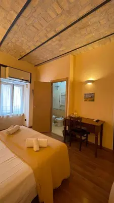 a bedroom with a bed and a desk and a table at Holiday Suite Roma in Rome