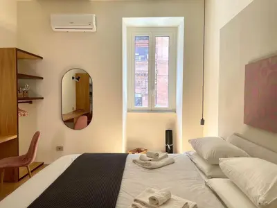 a bedroom with a bed and a mirror and a couch at La Dolce Vita - Old Testaccio Luxury Apartment in Rome