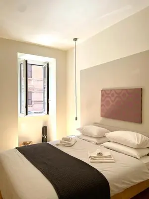 a bedroom with a large bed with two towels on it at La Dolce Vita - Old Testaccio Luxury Apartment in Rome