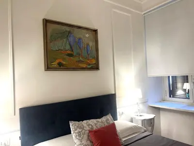 a bedroom with a painting hanging above a bed at INTERNO ROMA in Rome