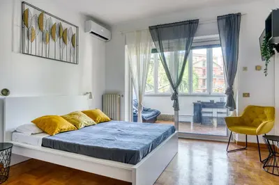 a bedroom with a bed and a chair and a window at Bright Apartment near Vatican City by RHR in Rome