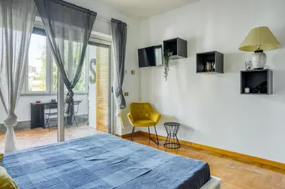 a bedroom with a blue bed and a yellow chair at Bright Apartment near Vatican City by RHR in Rome