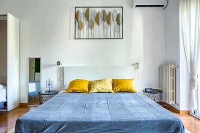 a bedroom with a large blue bed with yellow pillows at Bright Apartment near Vatican City by RHR in Rome
