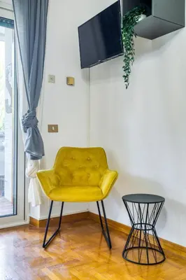 a yellow chair and a table in a room at Bright Apartment near Vatican City by RHR in Rome
