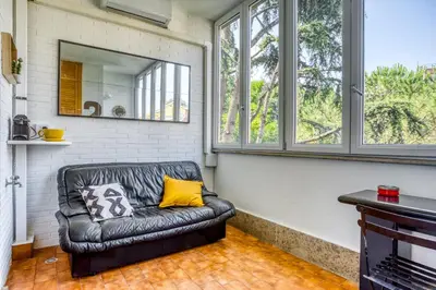 a leather couch in a room with windows at Bright Apartment near Vatican City by RHR in Rome
