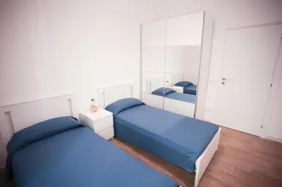 a bedroom with two beds and a mirror at Vatican Museum Apartment in Rome