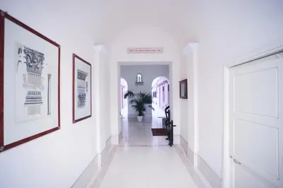 a hallway with white walls and pictures on the walls at Vatican Museum Apartment in Rome