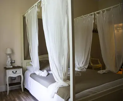 a bedroom with a canopy bed with white curtains at Trastevere Belvedere B&B in Rome