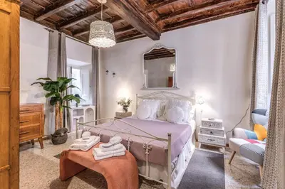 a bedroom with a bed and a chair and a mirror at Capocci Luxury Home in Rome
