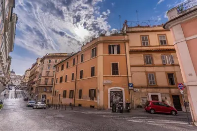 a building on a street with a red car parked in front at Capocci Luxury Home in Rome