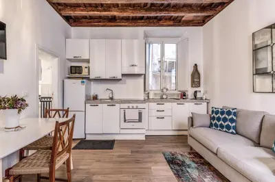 a kitchen and living room with a couch and a table at Capocci Luxury Home in Rome