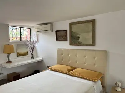 a bedroom with a white bed with a gold bedspread at Giglio Penthouse and Terrace in Rome