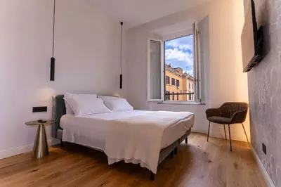 a white bedroom with a bed and a window at Scipioni Luxury Suite in Rome