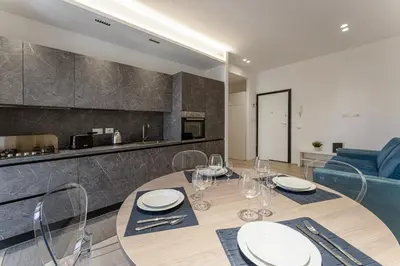 a dining room with a table and a kitchen at Vatican Suite Apartament Roma in Rome