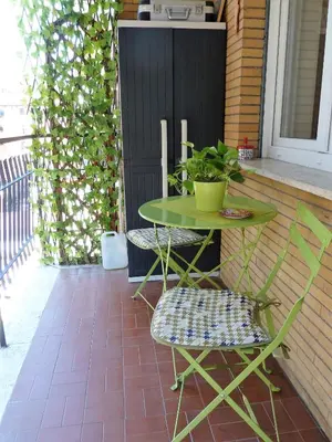 a green table and chairs on a patio at Stesi Vacanze in Rome