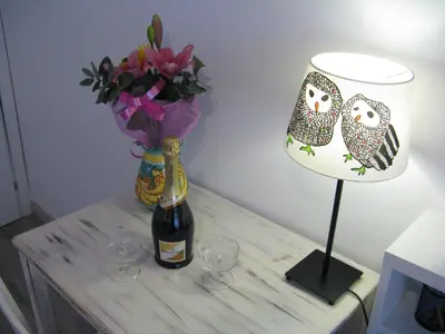 a table with a bottle of wine and a vase with flowers at Stesi Vacanze in Rome