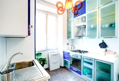 a kitchen with blue and white cabinets and a sink at Antinori Testaccio Cozy Apartment in Rome