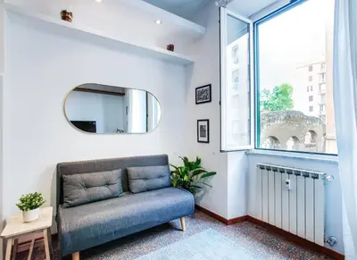 a living room with a blue couch and a window at Antinori Testaccio Cozy Apartment in Rome