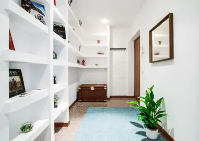 a hallway with white shelves and a potted plant at Antinori Testaccio Cozy Apartment in Rome