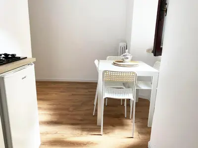 a white table and chairs in a kitchen at Germanico Apartments in Rome