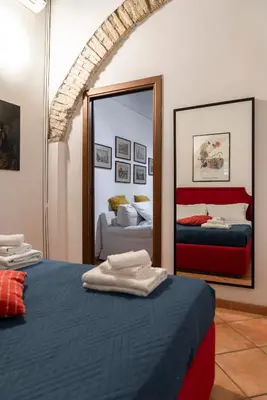 a bedroom with two beds and a mirror at Casa De' Medici in via Giulia in Rome